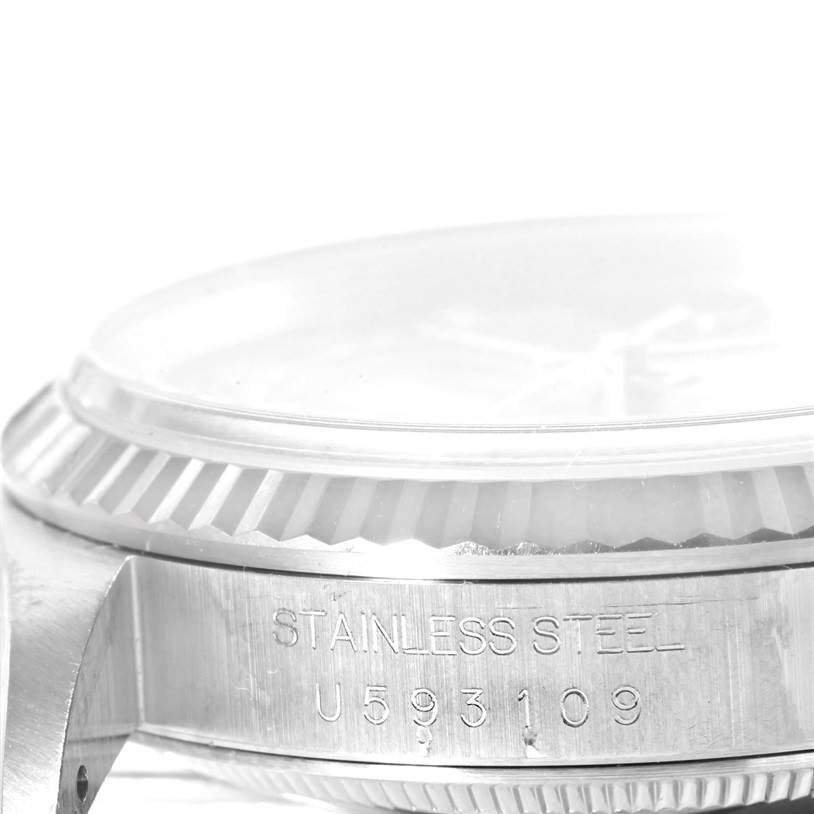 This image shows a close-up side view of the casing and bezel of a Rolex Datejust 16234 Men
s Stainless Steel Pink Dial 16234 Men
s Stainless Steel Pink Dial watch, displaying "STAINLESS STEEL" and a serial number.