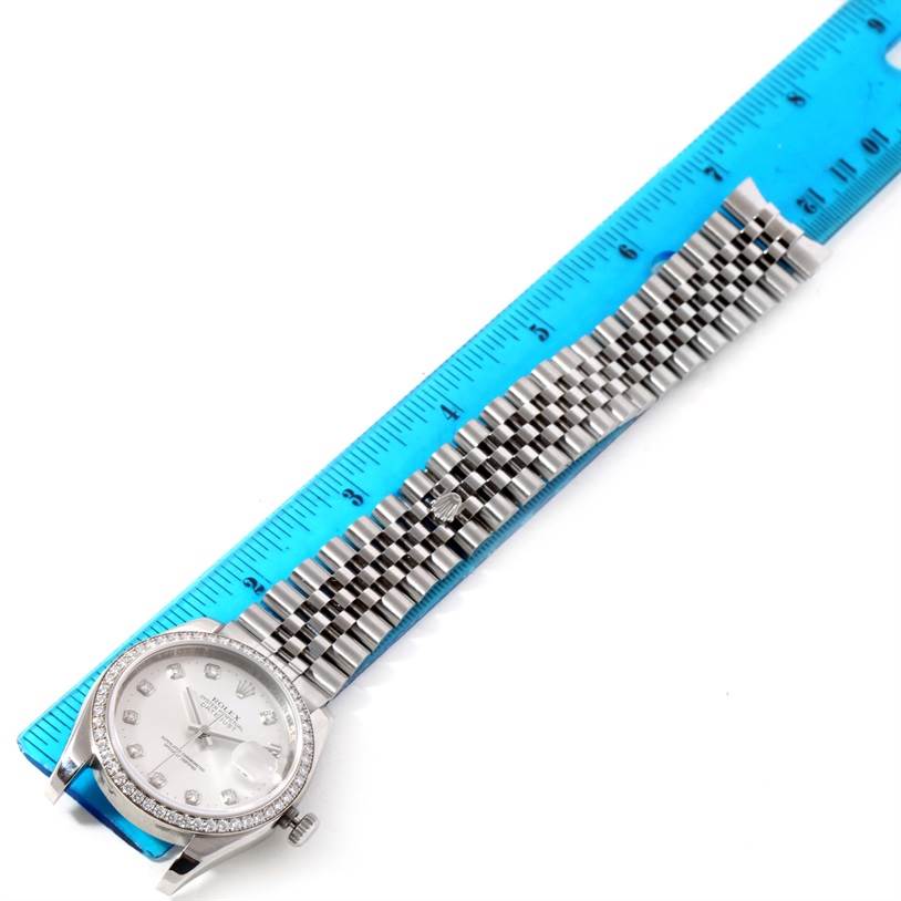 This image shows the face and band of a Rolex Datejust 116244 Men's Stainless Steel Silver Dial 116244 Men's Stainless Steel Silver Dial watch laid alongside a blue ruler.