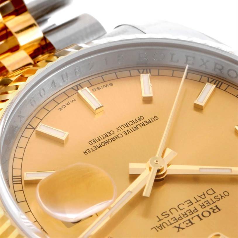 This close-up image of a Rolex Datejust 116233 Men's Stainless Steel Champagne Dial 116233 Men's Stainless Steel Champagne Dial watch shows a portion of its gold dial, hands, date magnifier, and part of the bezel.