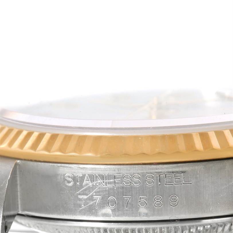 This image shows a close-up of the side of a Rolex Datejust 16233 Men's Steel and Gold (two tone) White Dial 16233 Men's Steel and Gold (two tone) White Dial watch, highlighting the fluted bezel and stainless steel case.