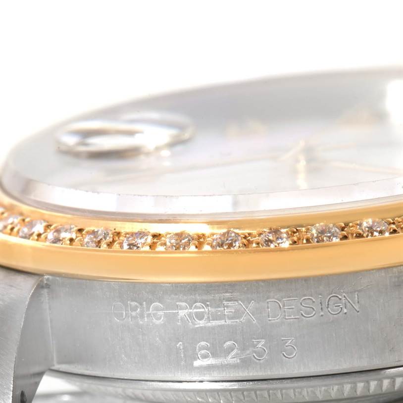 The image shows a close-up of the Rolex Datejust 16233 Men
s Steel and Gold (two tone) Mother of Pearl Dial 16233 Men
s Steel and Gold (two tone) Mother of Pearl Dial model
s side, featuring its diamond bezel and part of the watch case with markings.