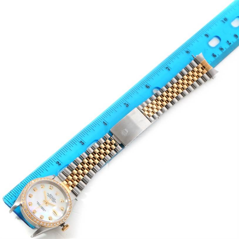 The Rolex Datejust 16233 Men
s Steel and Gold (two tone) Mother of Pearl Dial 16233 Men
s Steel and Gold (two tone) Mother of Pearl Dial watch is shown laid flat with its bracelet stretched out next to a ruler for measurement.