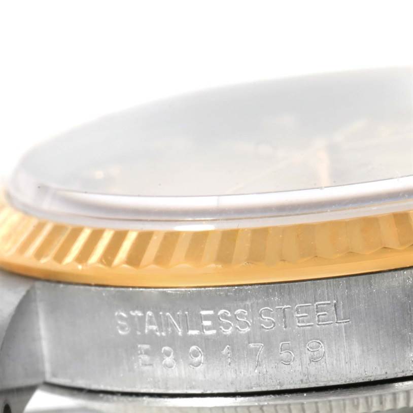 The image shows a close-up side view of a Rolex Datejust 16233 Men's Steel and Gold (two tone) Champagne Dial 16233 Men's Steel and Gold (two tone) Champagne Dial watch, focusing on the fluted bezel and case with "STAINLESS STEEL" engraving.