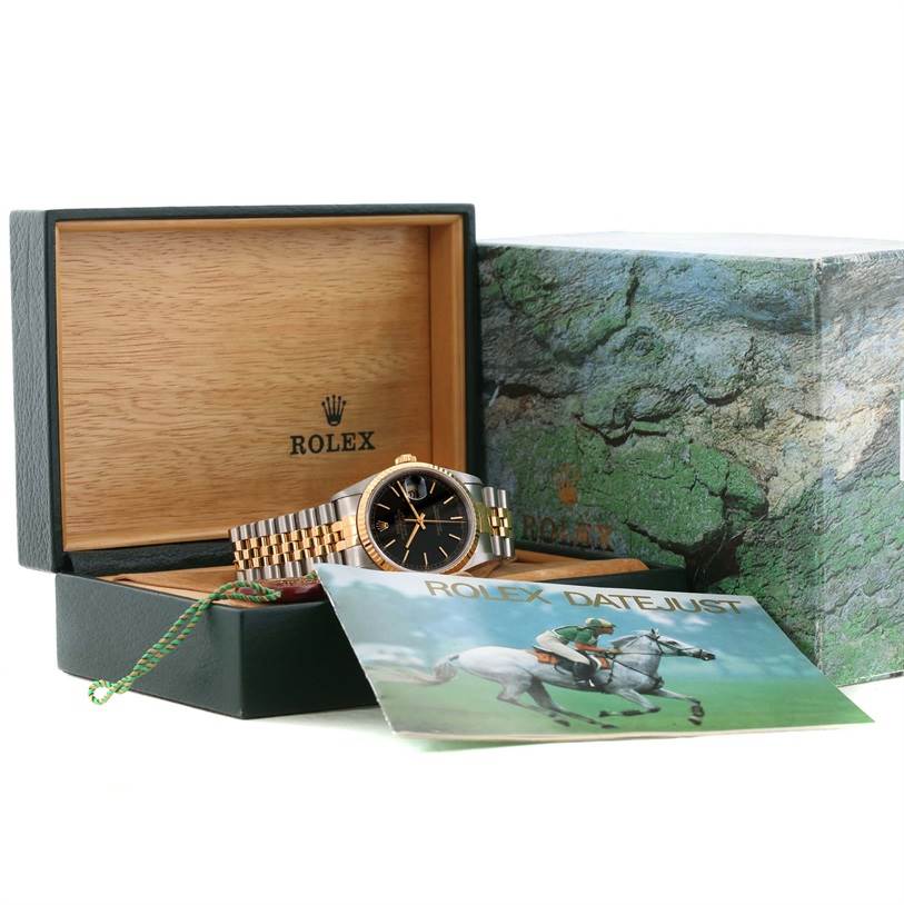The Rolex Datejust 16233 Men's Steel and Gold (two tone) Black Dial 16233 Men's Steel and Gold (two tone) Black Dial watch is displayed inside its open box with its accessories, including a booklet and tags, visible.