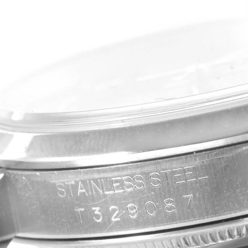 This image shows a close-up of the side of a Rolex Datejust 16200 Men's Stainless Steel Blue Dial 16200 Men's Stainless Steel Blue Dial watch, focusing on the stainless steel case with engraved serial numbers.