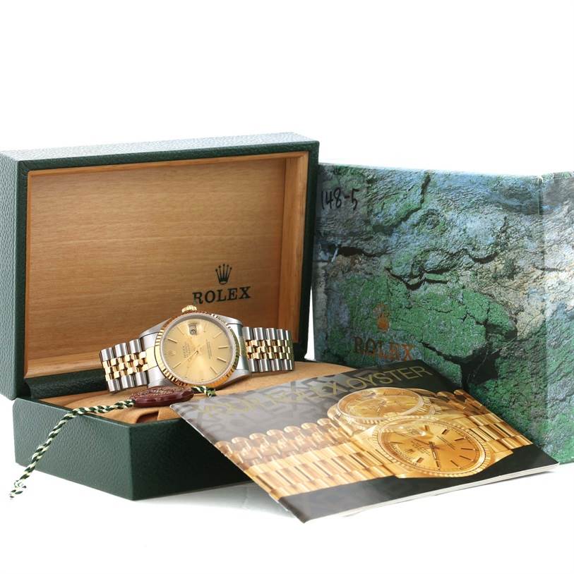The image shows a Rolex Datejust 16233 Men's Steel and Gold (two tone) Champagne Dial 16233 Men's Steel and Gold (two tone) Champagne Dial watch placed in its box with accompanying packaging and a booklet.
