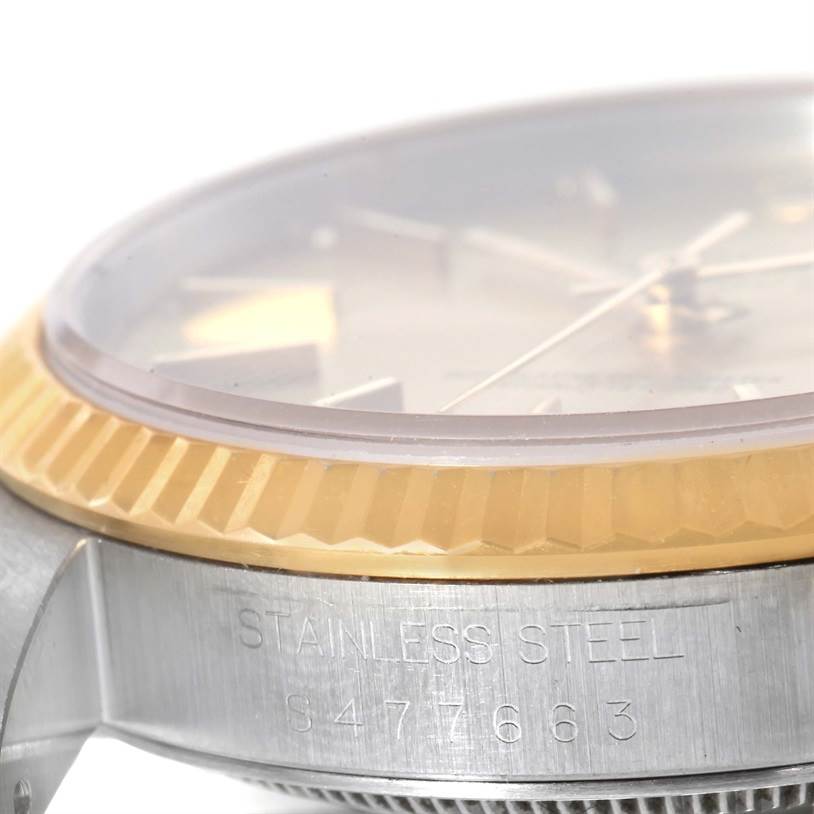 This image shows a close-up side angle of a Rolex Datejust 16233 Men's Steel and Gold (two tone) Champagne Dial 16233 Men's Steel and Gold (two tone) Champagne Dial watch, highlighting its bezel and part of the case with engraved serial number.