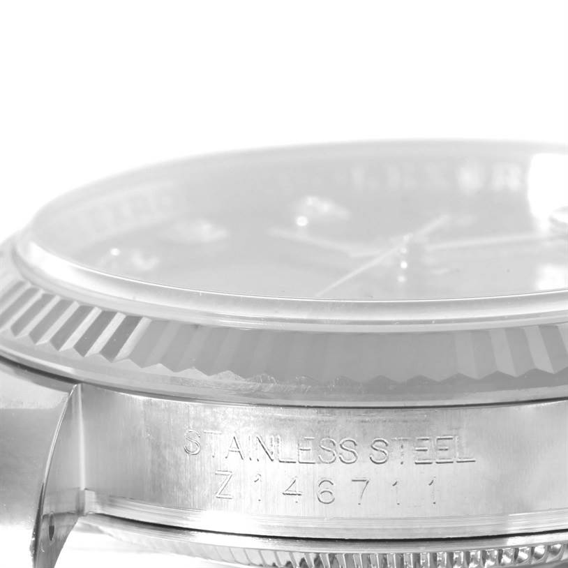 The image shows a close-up side view of a Rolex Datejust 116234BKDO Men's Stainless Steel Silver Dial 116234BKDO Men's Stainless Steel Silver Dial watch, focusing on the stainless steel case and fluted bezel.