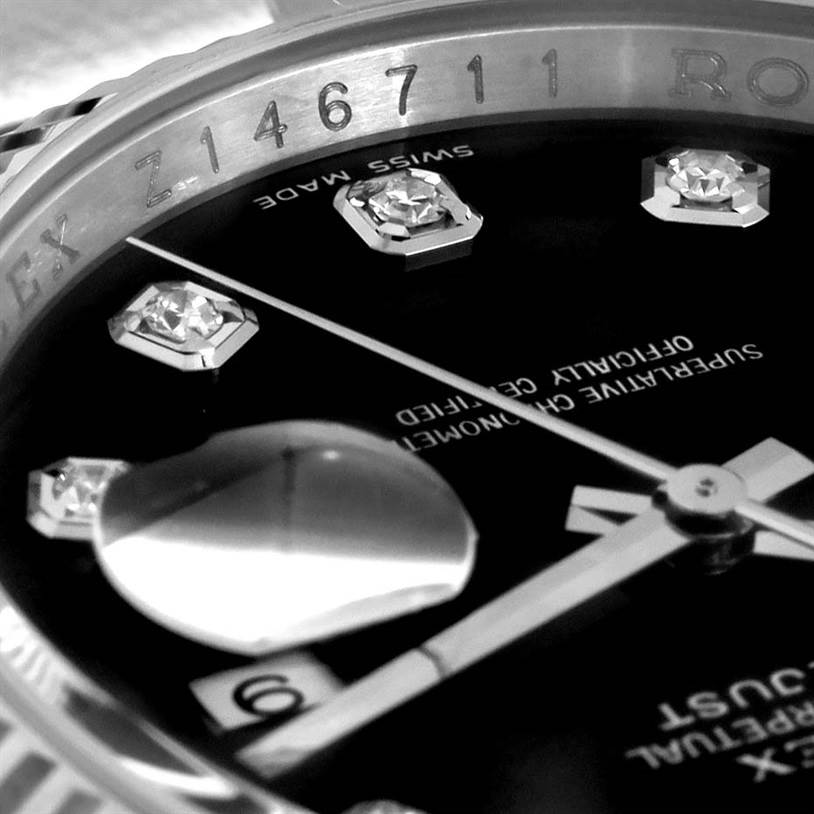 This close-up image of a Rolex Datejust 116234BKDO Men's Stainless Steel Silver Dial 116234BKDO Men's Stainless Steel Silver Dial watch shows the bezel with serial numbers, diamond hour markers, and hands.