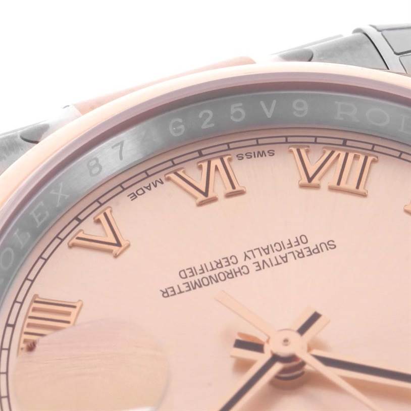 The image shows a close-up of the dial and bezel of a Rolex Datejust 116201PKRO Men's Steel and Gold (two tone) Pink Dial 116201PKRO Men's Steel and Gold (two tone) Pink Dial, highlighting its Roman numerals and text detail.