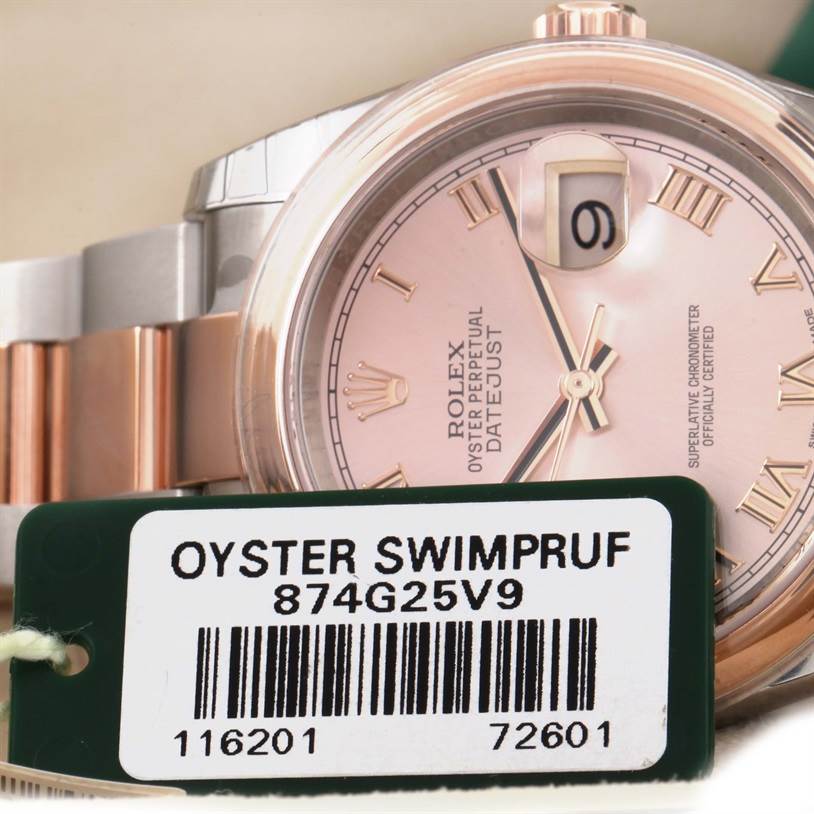 The image shows a close-up angle of a Rolex Datejust 116201PKRO Men's Steel and Gold (two tone) Pink Dial 116201PKRO Men's Steel and Gold (two tone) Pink Dial watch face and part of the bracelet with a "Oyster Swimpruf" tag.
