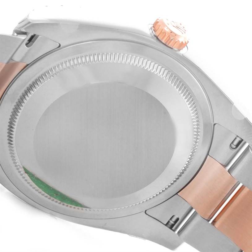 This image shows the back case, crown, and part of the bracelet of a Rolex Datejust 116201PKRO Men's Steel and Gold (two tone) Pink Dial 116201PKRO Men's Steel and Gold (two tone) Pink Dial watch in a partially open position.