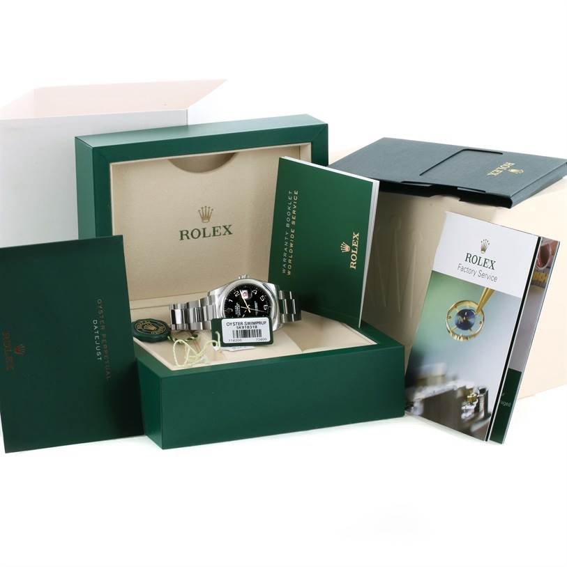 The photo shows a Rolex Datejust 116200BKAO Men
s Stainless Steel Black Dial 116200BKAO Men
s Stainless Steel Black Dial watch and accessories from a top angle inside its original packaging with booklets.