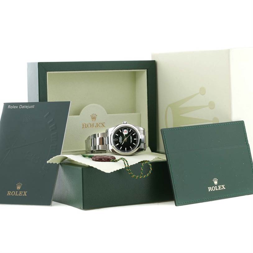 The image shows a Rolex Datejust 116200BKSO Men's Stainless Steel Black Dial 116200BKSO Men's Stainless Steel Black Dial watch positioned inside its box, accompanied by manuals and warranty/booklet.