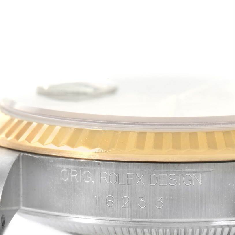 The image shows a close-up of the engraved side of a Rolex Datejust 16233 Men
s Steel and Gold (two tone) Champagne Dial 16233 Men
s Steel and Gold (two tone) Champagne Dial watch, highlighting the case and fluted bezel.