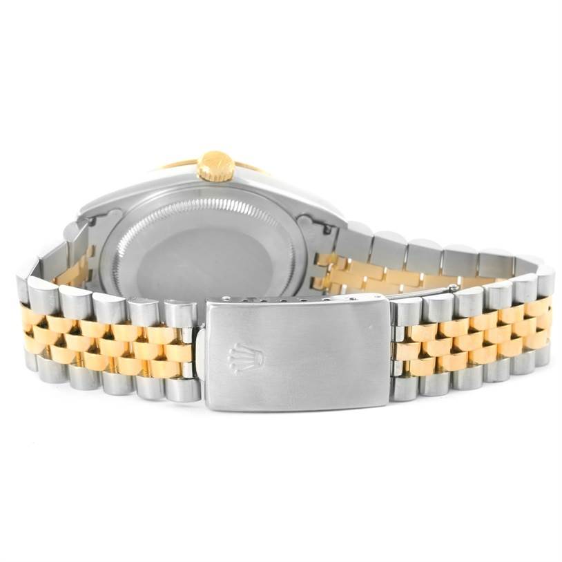 This image shows the backside of a Rolex Datejust 16233 Men
s Steel and Gold (two tone) Champagne Dial 16233 Men
s Steel and Gold (two tone) Champagne Dial watch, highlighting its case back, crown, and Jubilee bracelet with a clasp.