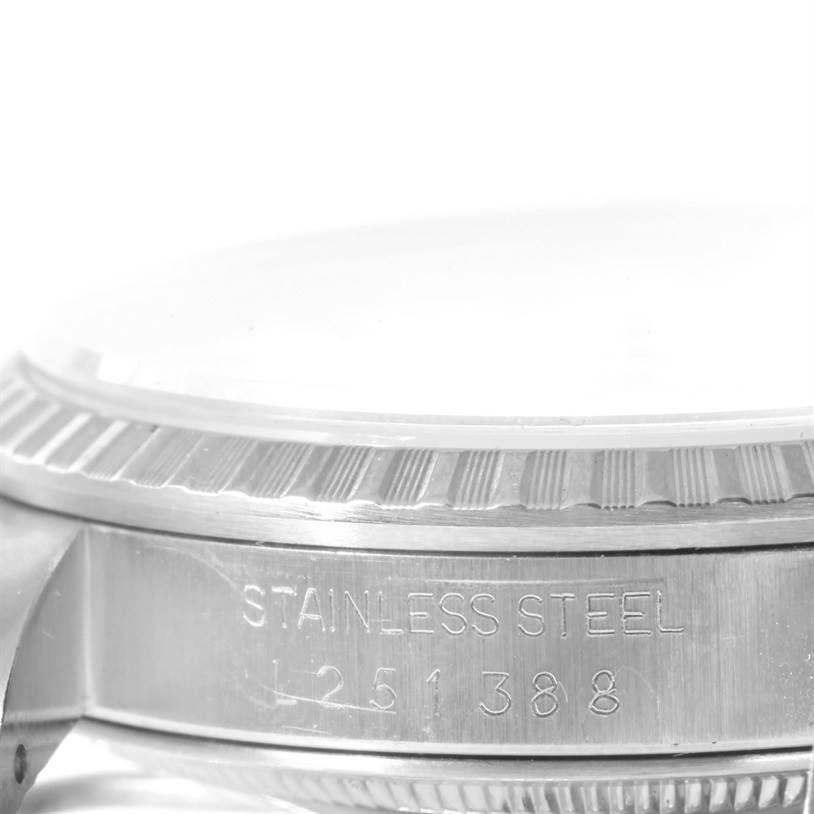 This image shows a close-up side view of a Rolex Datejust 16220 Men's Stainless Steel White Dial 16220 Men's Stainless Steel White Dial watch, highlighting its bezel and part of the stainless steel casing.