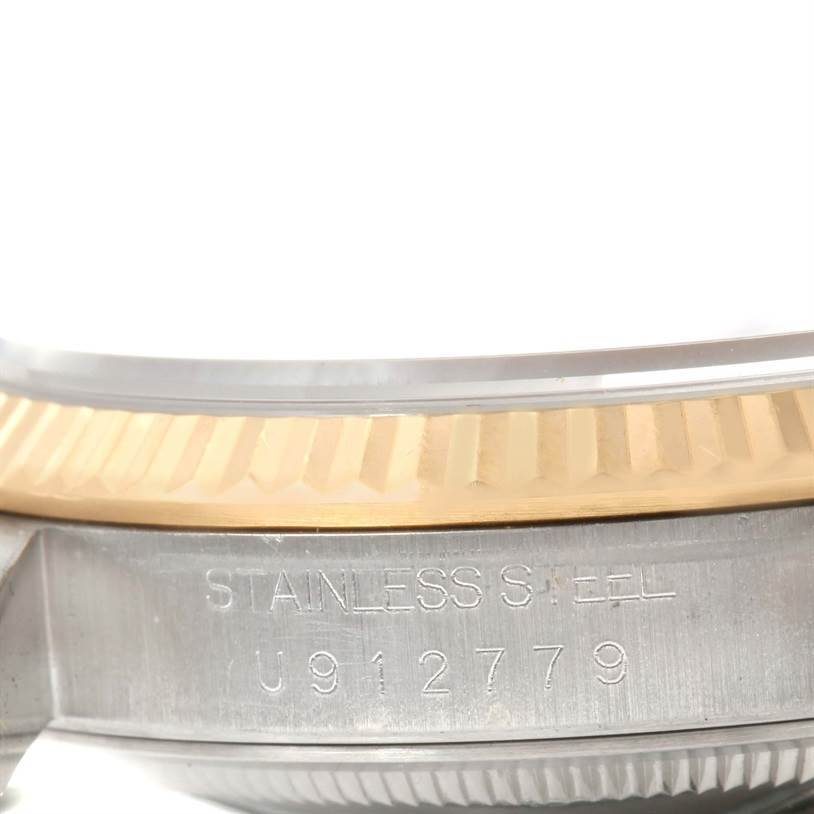 This close-up image of the Rolex Datejust 16233 Men
s Steel and Gold (two tone) Black Dial 16233 Men
s Steel and Gold (two tone) Black Dial shows the side of the case, including the stainless steel engraving and part of the fluted bezel.