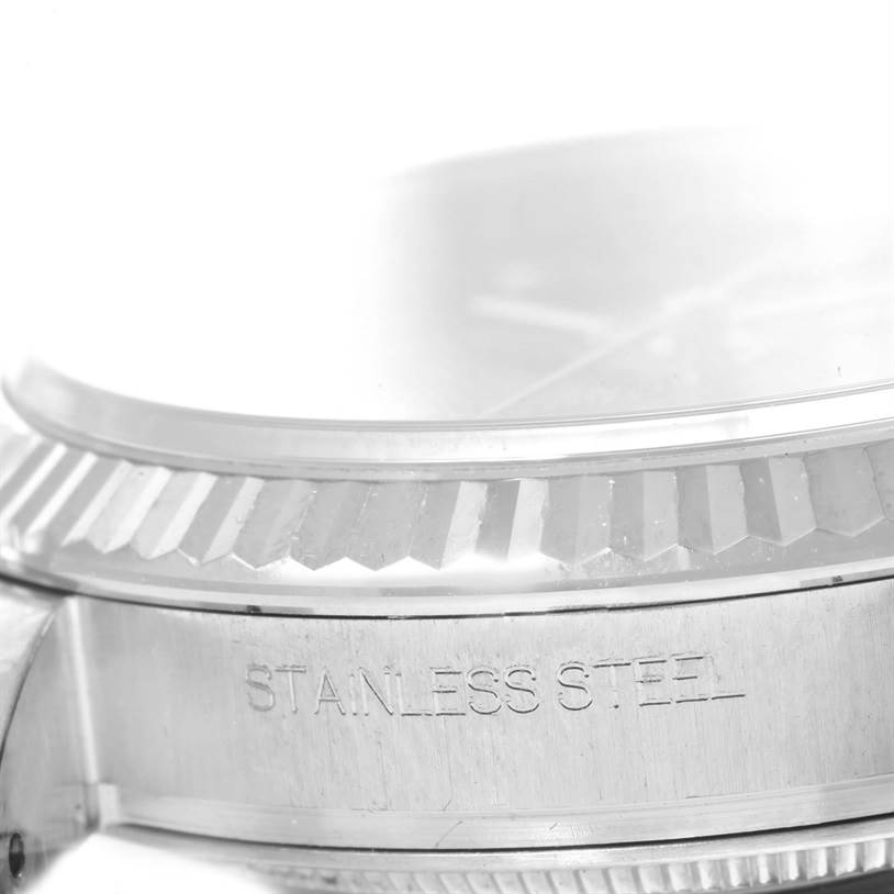 The image shows a close-up of the bezel and part of the case of a Rolex Datejust 116234 Men
s Stainless Steel Black Dial 116234 Men
s Stainless Steel Black Dial watch, highlighting the "Stainless Steel" engraving.