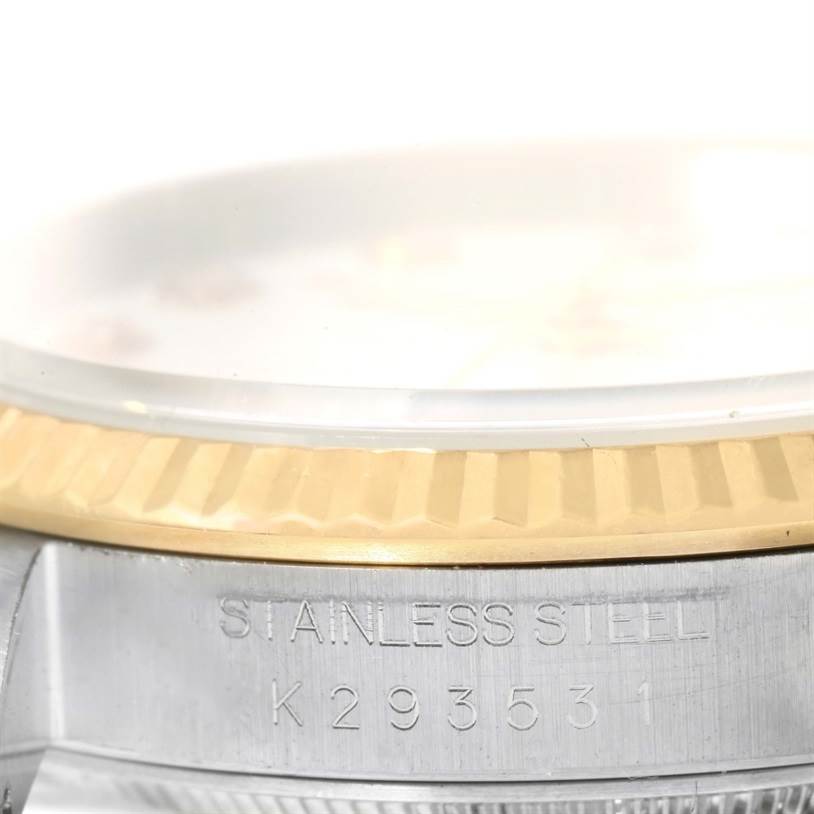 This image shows a close-up of the stainless steel case and fluted bezel of a Rolex Datejust 16233 Men's Steel and Gold (two tone) White Dial 16233 Men's Steel and Gold (two tone) White Dial watch.