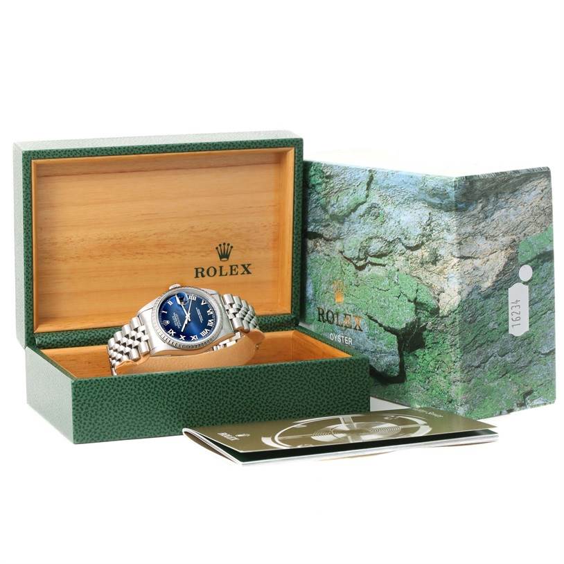 The Rolex Datejust 16220 Men's Stainless Steel Blue Dial 16220 Men's Stainless Steel Blue Dial watch is shown in an open box, along with its packaging and accompanying booklet, viewed from the front.