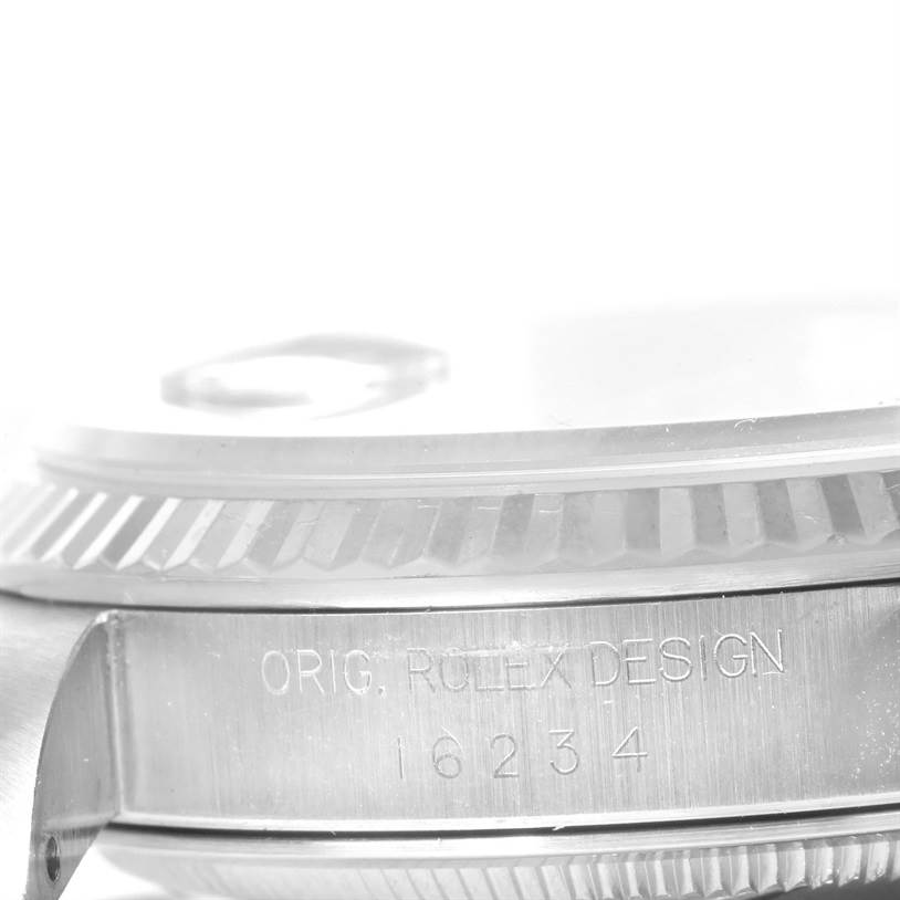 This close-up angle of the Rolex Datejust 16234 Men's Stainless Steel White Dial 16234 Men's Stainless Steel White Dial watch shows the ridged bezel and the side of the case with the engraving.