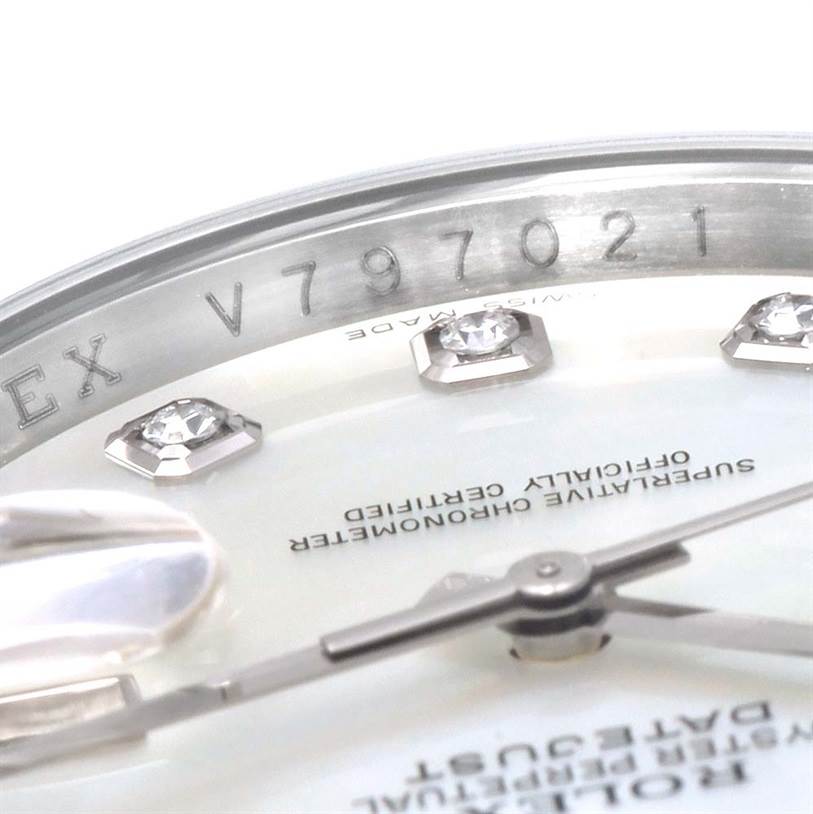 Close-up of a Rolex Datejust 116244 Men's Stainless Steel Mother of Pearl Dial 116244 Men's Stainless Steel Mother of Pearl Dial watch showing the serial number, diamonds, hands, and part of the dial.