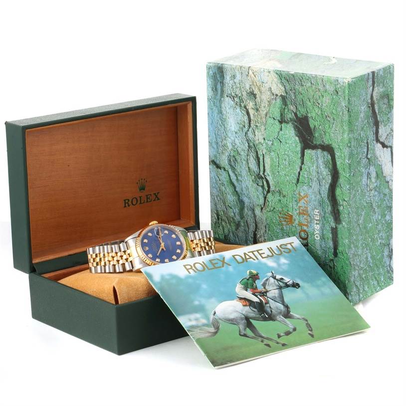 This image shows a Rolex Datejust 16233 Men's Steel and Gold (two tone) Blue Dial 16233 Men's Steel and Gold (two tone) Blue Dial watch from a front angle, along with its box and accompanying booklet.