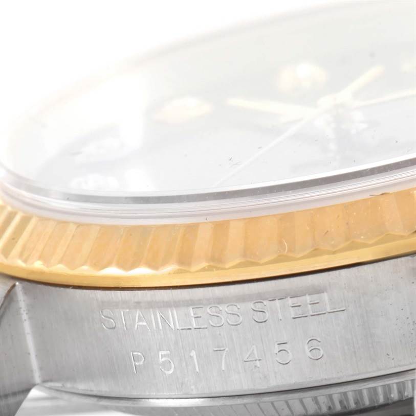 This image shows a close-up side view of a Rolex Datejust 16233 Men's Steel and Gold (two tone) Blue Dial 16233 Men's Steel and Gold (two tone) Blue Dial, highlighting the bezel, crystal, and part of the case with "STAINLESS STEEL" engraved.