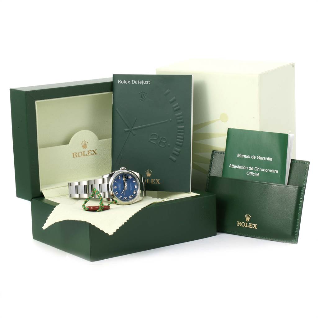The image shows a Rolex Datejust 116200 Men's Stainless Steel Blue Dial 116200 Men's Stainless Steel Blue Dial watch, its box, manuals, and warranty card from a front angle.