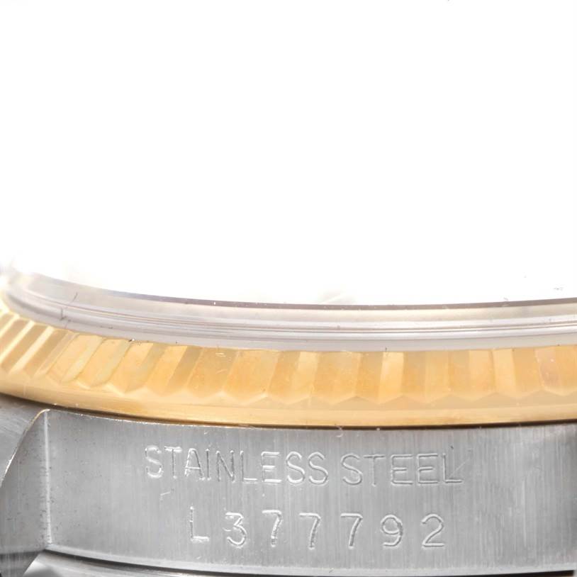 This image shows a close-up of the stainless steel casing and part of the fluted bezel of a Rolex Datejust 16233 Men's Steel and Gold (two tone) Beige Dial 16233 Men's Steel and Gold (two tone) Beige Dial watch.