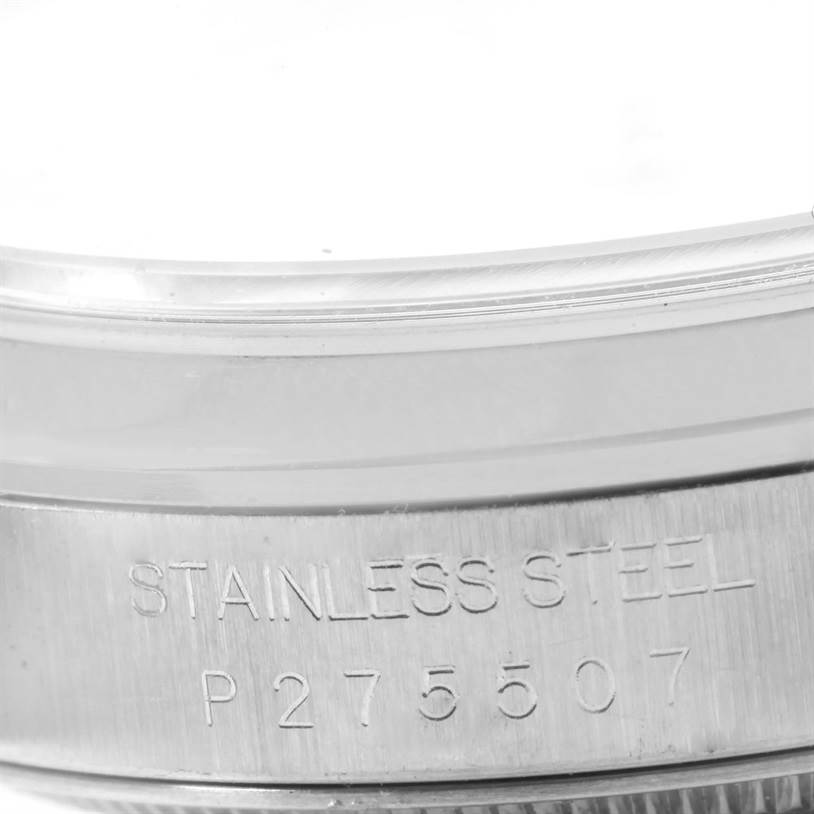 This close-up image shows the side of a Rolex Datejust 16200 Men
s Stainless Steel Silver Dial 16200 Men
s Stainless Steel Silver Dial watch, highlighting the "STAINLESS STEEL" engraving and part of the bezel.