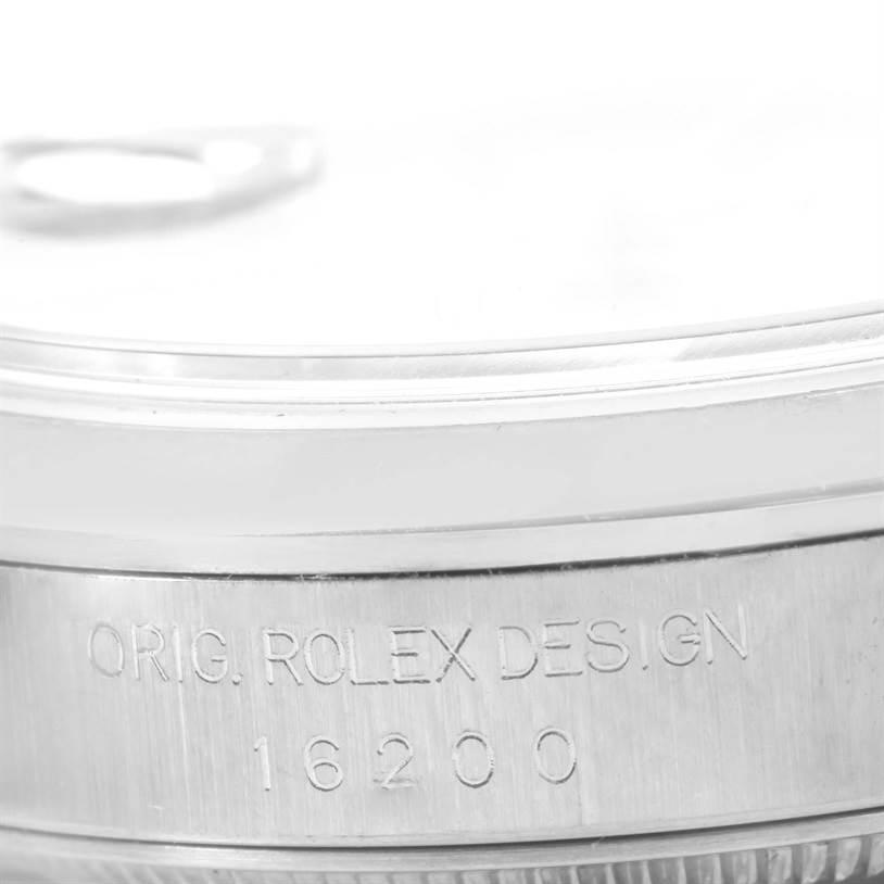 The image shows a close-up of the case side of a Rolex Datejust 16200 Men
s Stainless Steel Silver Dial 16200 Men
s Stainless Steel Silver Dial watch, highlighting the engraved serial number and "ORIG. ROLEX DESIGN."
