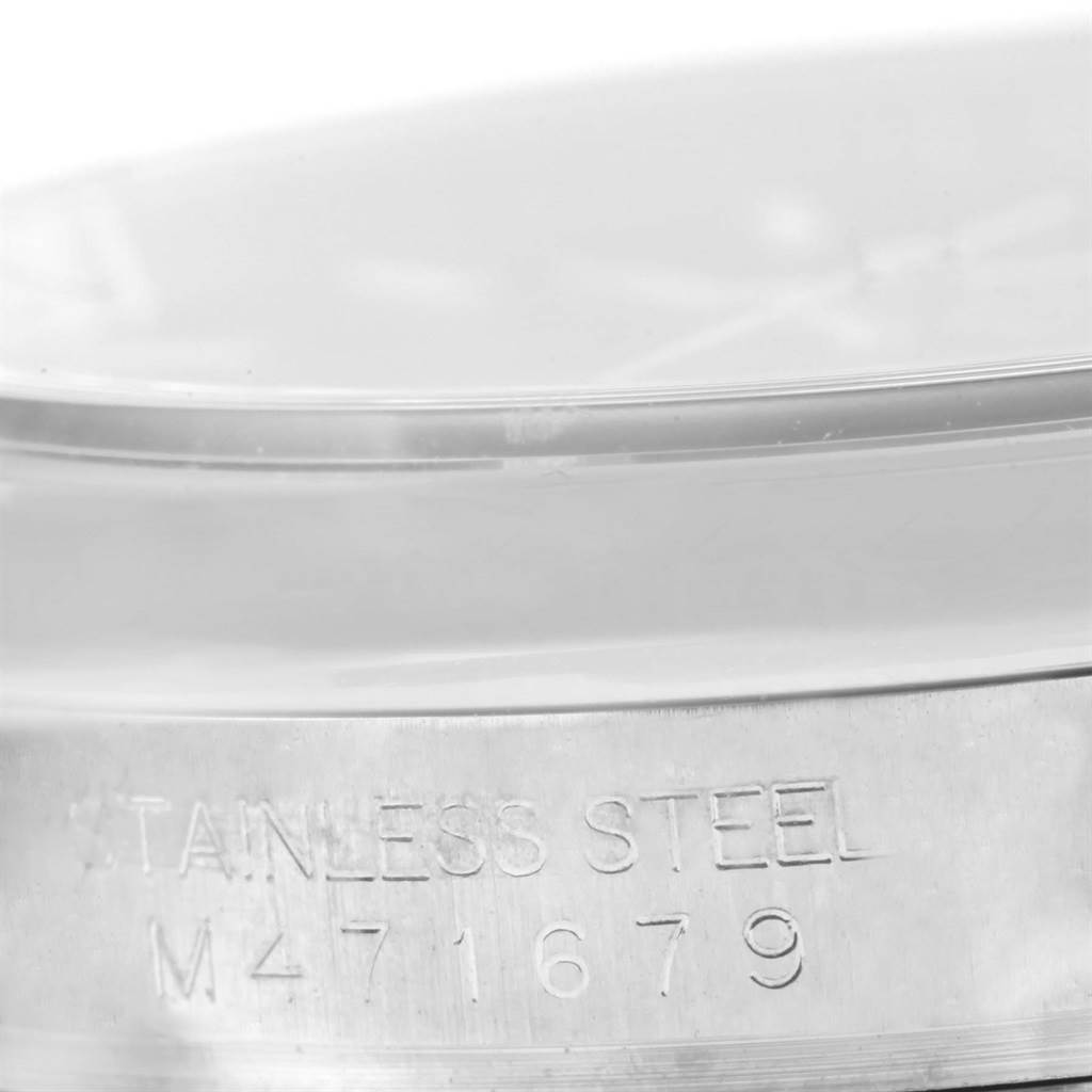 The image shows a close-up of the case's side of a Rolex Datejust 116200 Men's Stainless Steel Black Dial 116200 Men's Stainless Steel Black Dial watch, focusing on the serial number and material engraving.