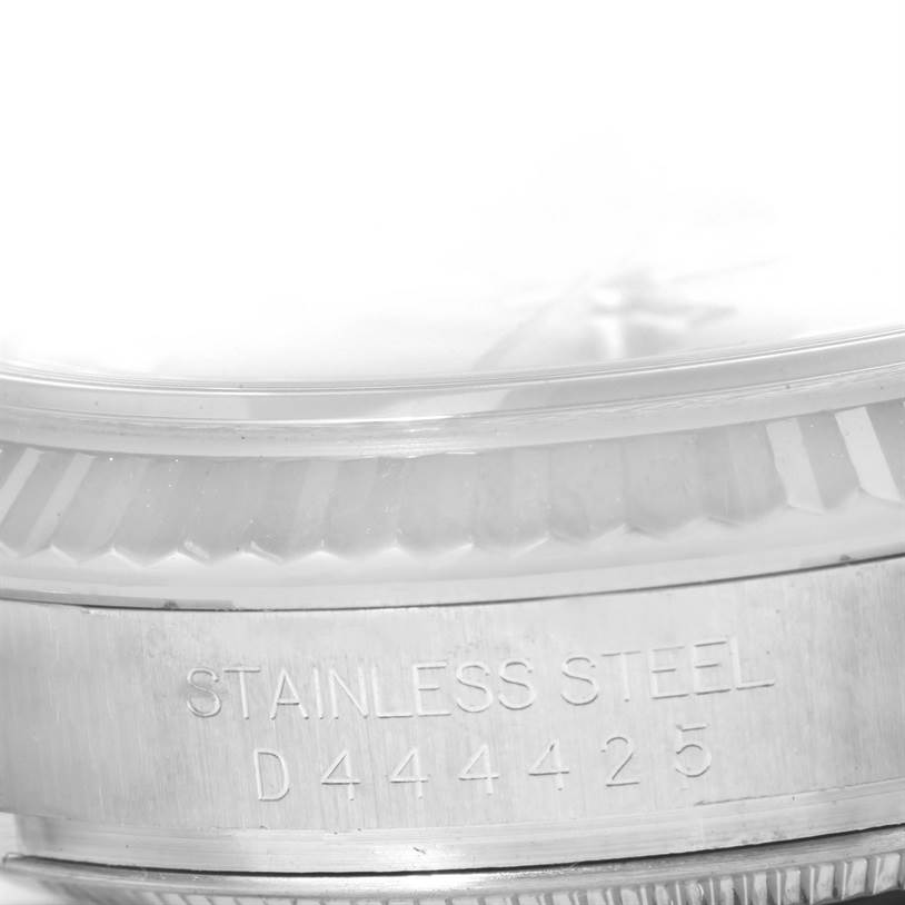 The image shows a close-up of the side of a Rolex Datejust 116234 Men's Stainless Steel Silver Dial 116234 Men's Stainless Steel Silver Dial watch, displaying the serial number and "STAINLESS STEEL" engraving.
