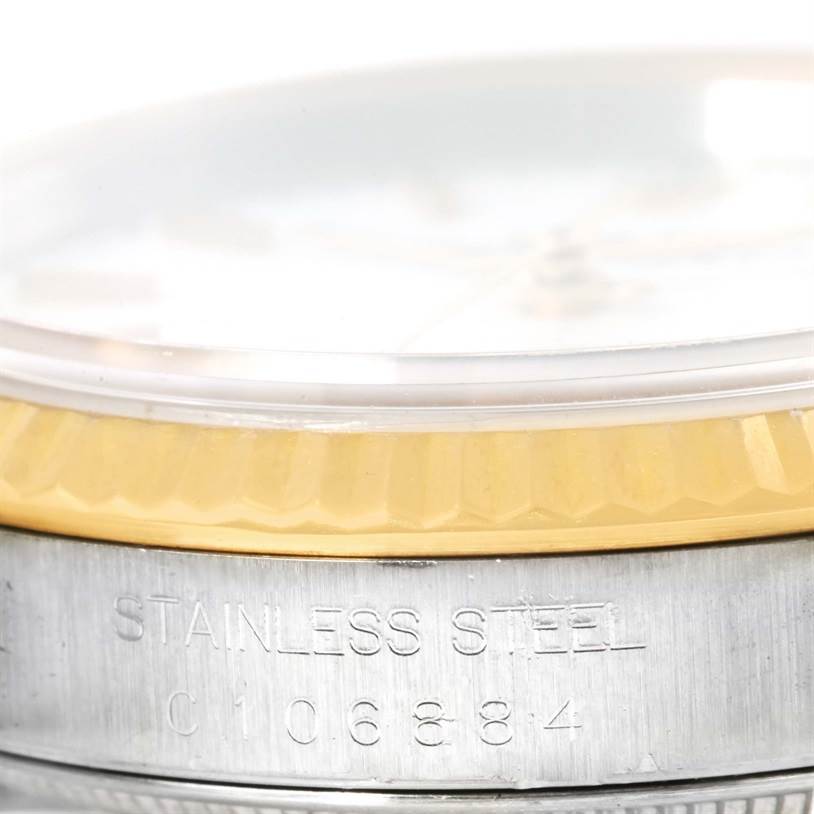 This image shows a close-up side view of the bezel and case of a Rolex Datejust 16233 Men's Steel and Gold (two tone) White Dial 16233 Men's Steel and Gold (two tone) White Dial watch, highlighting the serial number and "STAINLESS STEEL" inscription.