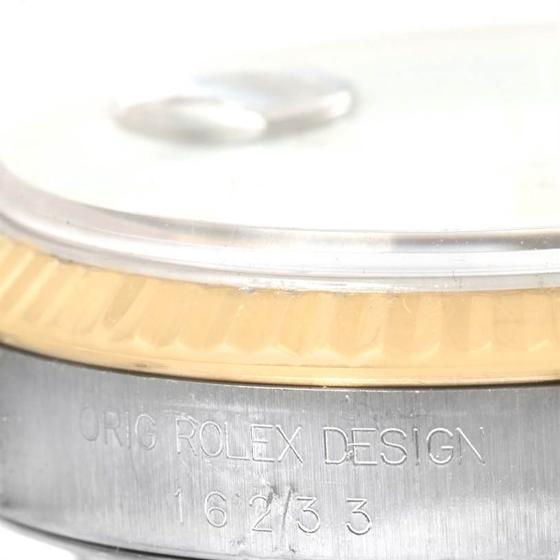 This image shows a close-up of the side and edge of a Rolex Datejust 16233 Men's Steel and Gold (two tone) White Dial 16233 Men's Steel and Gold (two tone) White Dial watch, highlighting the bezel and engraved model number.