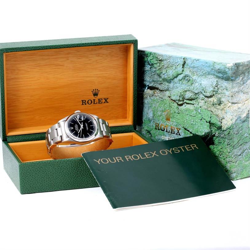 This image shows a Rolex Datejust 16200 Men
s Stainless Steel Black Dial 16200 Men
s Stainless Steel Black Dial watch, its presentation box, and a user manual angled slightly from the front.