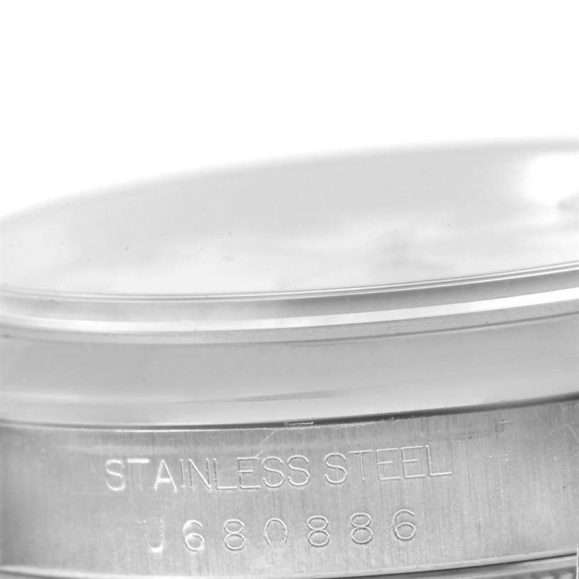 The image shows a close-up of the side of a Rolex Datejust 16200 Men
s Stainless Steel White Dial 16200 Men
s Stainless Steel White Dial watch case, highlighting the stainless steel material and serial number.