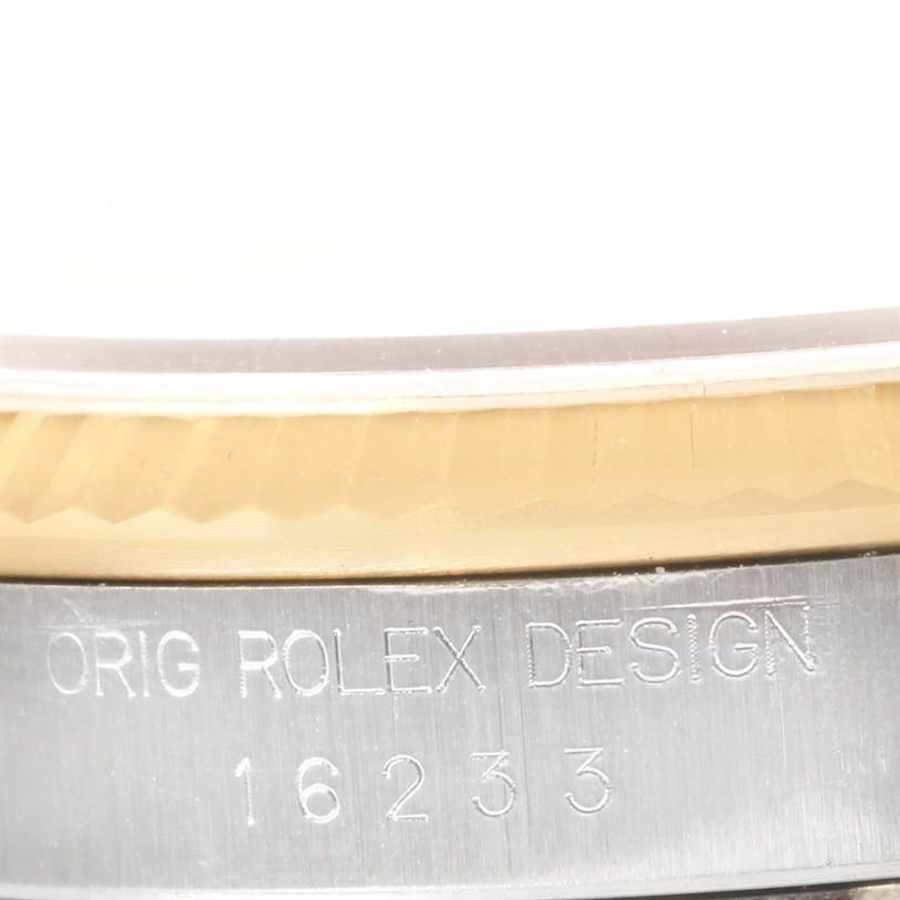 This close-up angle shows the edge of the bezel and the engraved serial number on the case of a Rolex Datejust 16233 Men's Steel and Gold (two tone) Champagne Dial 16233 Men's Steel and Gold (two tone) Champagne Dial watch.