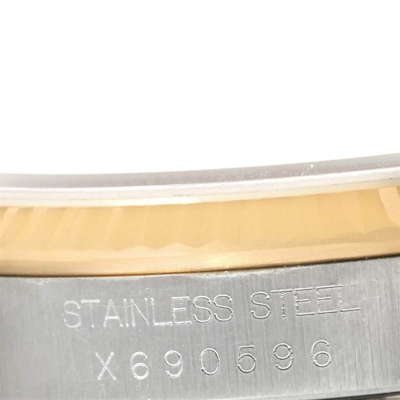 This close-up image shows part of the stainless steel case and serial number on a Rolex Datejust 16233 Men's Steel and Gold (two tone) Champagne Dial 16233 Men's Steel and Gold (two tone) Champagne Dial watch.