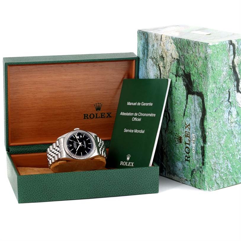 The image shows a Rolex Datejust 16220 Men
s Stainless Steel Black Dial 16220 Men
s Stainless Steel Black Dial in its box, along with the manual and certificate, revealing the watch face and bracelet from a front angle.