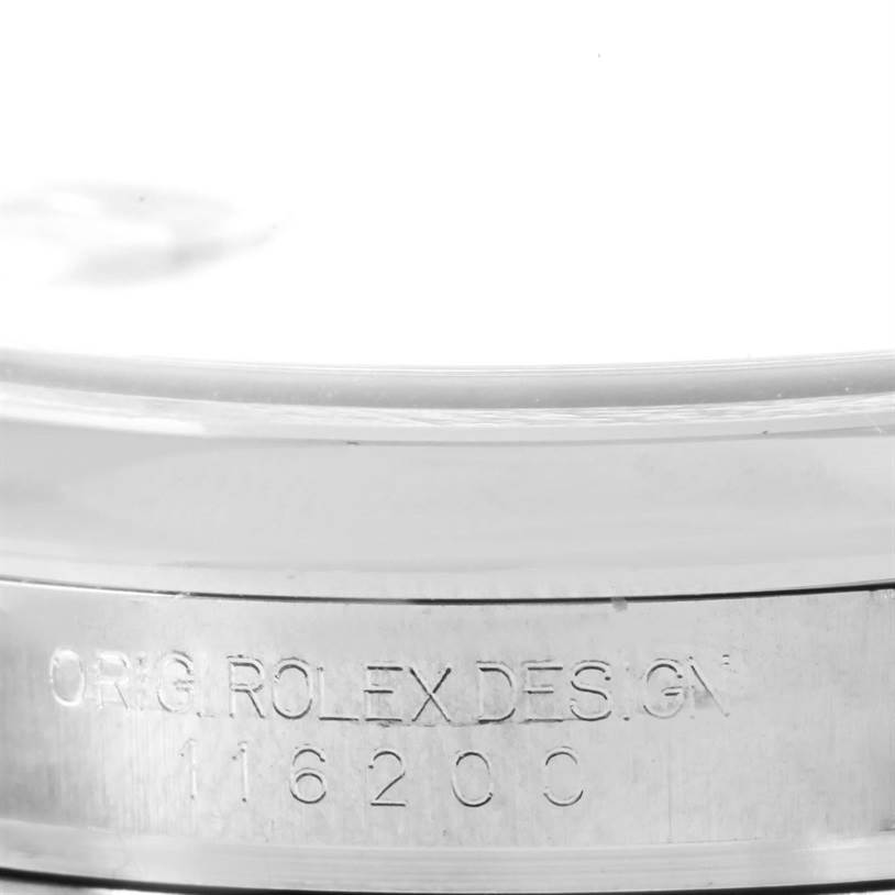 This close-up image of a Rolex Datejust 116200 Men
s Stainless Steel White Dial 116200 Men
s Stainless Steel White Dial shows the edge of the case with "ORIG. ROLEX DESIGN 116200" engraved.