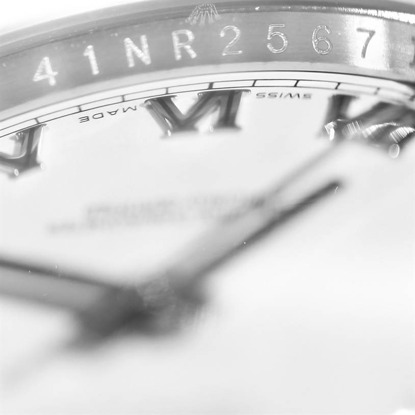 The image shows a close-up of the dial and bezel of a Rolex Datejust 116200 Men
s Stainless Steel White Dial 116200 Men
s Stainless Steel White Dial watch, focusing on the Roman numerals and inscription.