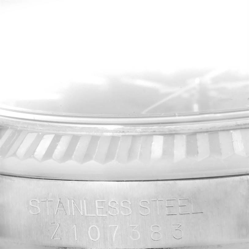 The image shows a close-up of the serial number and fluted bezel of a Rolex Datejust 116234 Men
s Stainless Steel Black Dial 116234 Men
s Stainless Steel Black Dial model watch.