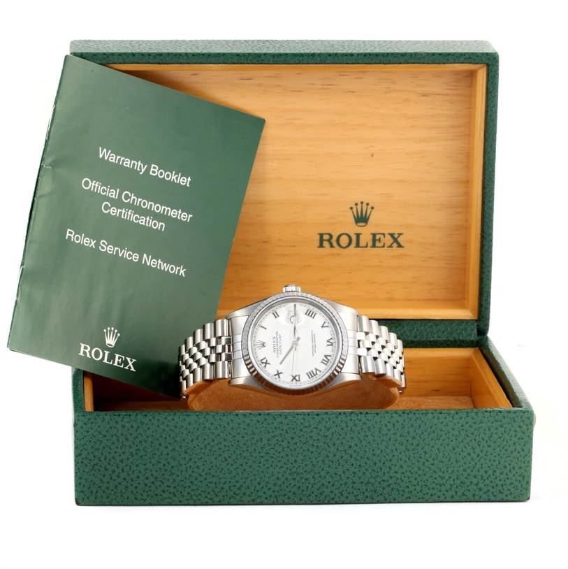 The Rolex Datejust 16234 Men
s Stainless Steel White Dial 16234 Men
s Stainless Steel White Dial watch is shown front-facing in its open box, alongside a green warranty booklet.