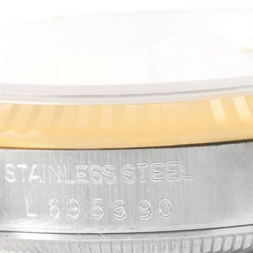 The image shows a close-up view of the side of a Rolex Datejust 16233 Men
s Steel and Gold (two tone) Champagne Dial 16233 Men
s Steel and Gold (two tone) Champagne Dial watch case, highlighting the stainless steel marking and part of the bezel.