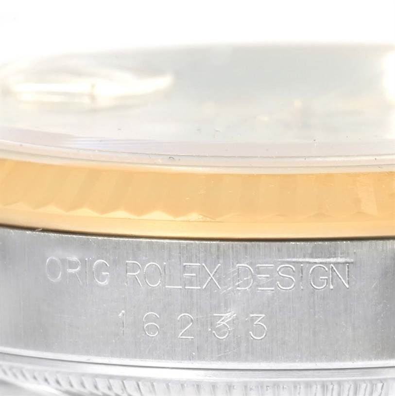 This close-up image shows the case and fluted bezel of a Rolex Datejust 16233 Men
s Steel and Gold (two tone) Beige Dial 16233 Men
s Steel and Gold (two tone) Beige Dial watch, with "ORIG ROLEX DESIGN" and model number engraved.