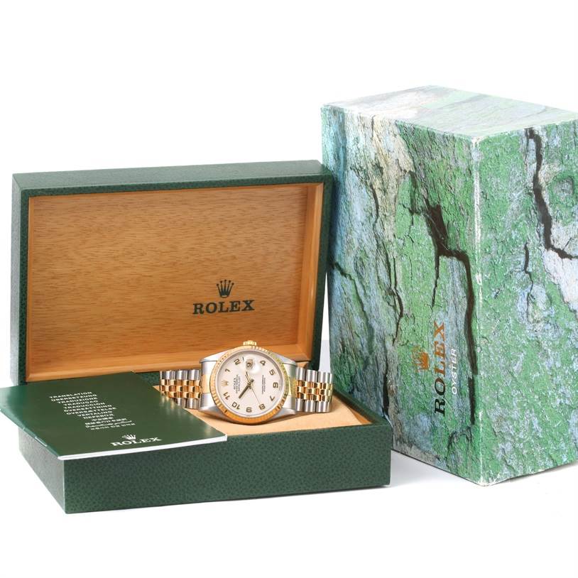 The Rolex Datejust 16233 Men
s Steel and Gold (two tone) Beige Dial 16233 Men
s Steel and Gold (two tone) Beige Dial watch is displayed in an open box with a booklet and outer box visible.