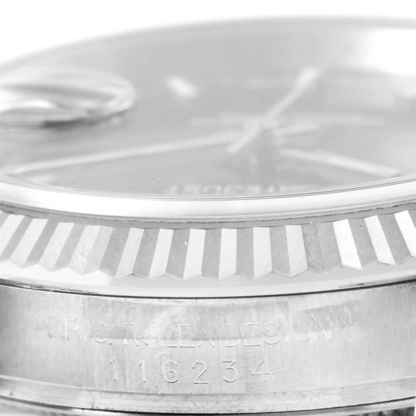 The image displays a close-up angle of a Rolex Datejust 116234 Men
s Stainless Steel Black Dial 116234 Men
s Stainless Steel Black Dial watch, showing its fluted bezel and part of the case with model number 16234.